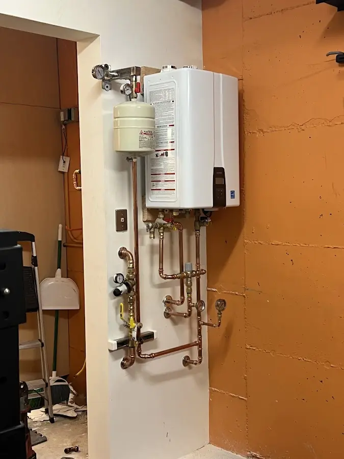 Plumbing technician inspecting water heater connections in Sugar Creek